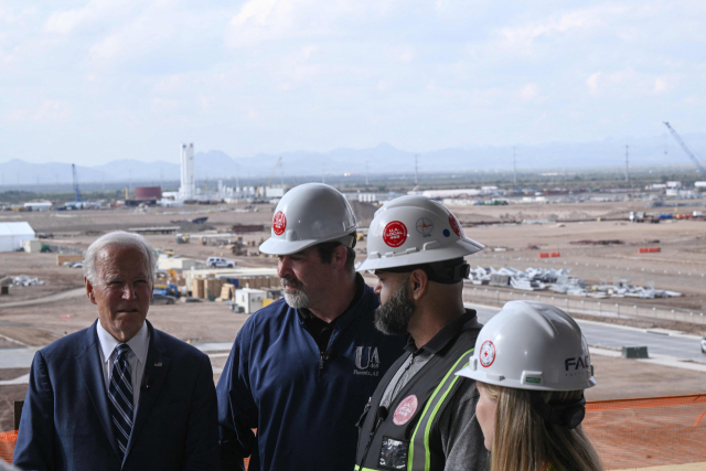US President Joe Biden (L) tours the TSMC Semiconductor Manufacturing Facility in Phoenix, Arizona, on December 6, 2022. (Photo by Brendan SMIALOWSKI / AFP)