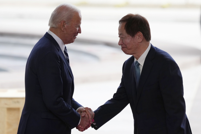 President Joe Biden, left, shakes hands with Taiwan Semiconductor Manufacturing Company Chairman Mark Liu, right, as the two meet on stage after touring the TSMC facility under construction in Phoenix, Tuesday, Dec. 6, 2022. (AP Photo/Ross D. Franklin)