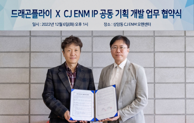 이종민(왼쪽) CJ ENM IP개발센터장과 권석홍 드래곤플라이 사업본부 본부장이 협약서를 들어보이고 있다. 사진 제공=CJ ENM