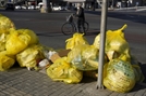 자전거를 탄 한 시민이 7일 베이징에서 의료폐기물로 표시된 노란색 쓰레기봉투 옆을 지나가고 있다. AP연합