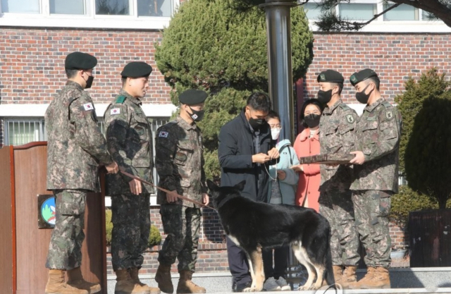 8일 오후 세종 금남면 육군 32보병사단 기동대대에서 군견 달관이의 은퇴식이 열린 가운데, 지난 2019년 실종 열흘째 만에 달관이의 도움으로 구조됐던 조은누리양(당시 14세) 가족이 은퇴식에 참석해 달관이에게 고마움을 전하고 있다. 연합뉴스 갈무리