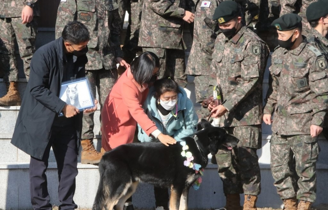 8일 오후 세종 금남면 육군 32보병사단 기동대대에서 군견 달관이의 은퇴식이 열린 가운데, 지난 2019년 실종 열흘째 만에 달관이의 도움으로 구조됐던 조은누리양(당시 14세) 가족이 은퇴식에 참석해 달관이에게 고마움을 전하고 있다. 연합뉴스 갈무리