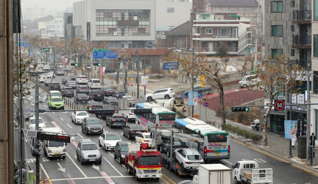 6일 청주시에 1㎝ 안팎의 눈이 내린 가운데 출근길 시내 중심지에 차들이 길게 늘어서 있다. 연합뉴스