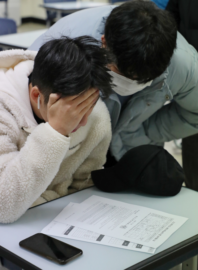 수험생들이 9일 종로구 경복고등학교에서 성적표를 보고 있다. 연합뉴스