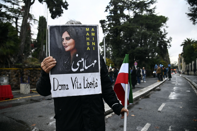 지난 10일(현지시간) 이탈리아 로마 주재 이란 대사관 앞에서 한 시위자가 '여성, 삶, 자유'라고 적힌 메시지와 함께 의문사한 마흐사 아미니의 사진이 담긴 플래카드를 들고 있다. EPA연합뉴스