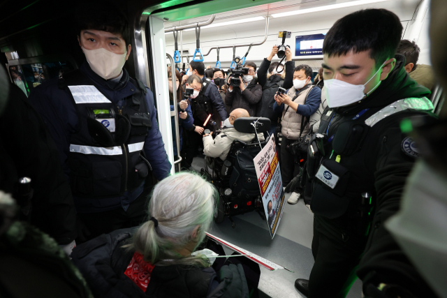 전국장애인차별철폐연대(전장연) 회원들이 지난 13일 오전 서울 용산구 4호선 삼각지역에서 출근길 지하철 탑승 시위를 하고 있다.