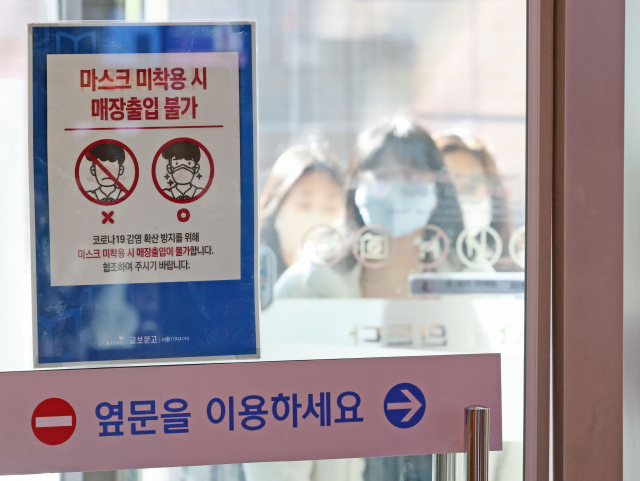 7일 서울의 한 대형 서점에 설치된 마스크 착용 안내문의 모습. 이날 질병관리청은 마스크 의무 조정 이행시기를 내년 1월에서 3월로 보고 있다고 밝혔다. 연합뉴스