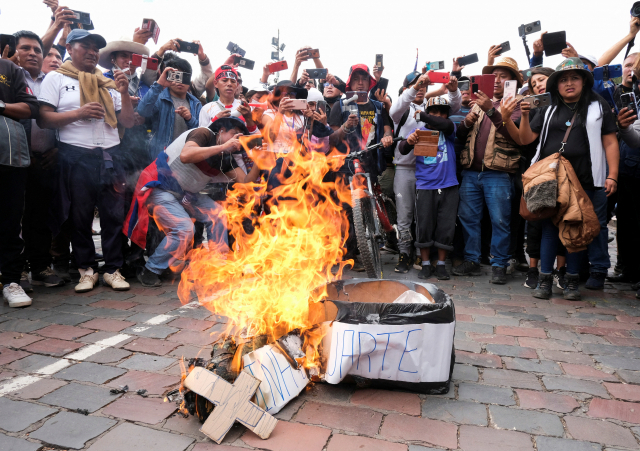 14일(현지 시간) 페루에서 반정부 시위대가 디나 볼루아르테 신임 대통령의 ‘가짜 관’을 불태우고 있다. 로이터통신