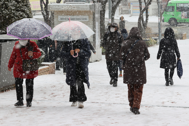 15일 서울 마포구청 인근에서 시민들이 우산이나 외투 모자를 쓰고 걷고 있다. 연합뉴스