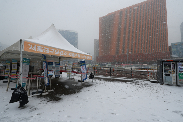 서울 지역에 많은 눈이 내린 15일 오후 서울역 광장에 마련된 코로나19 임시선별검사소 앞에 눈이 소복이 쌓여 있다. 연합뉴스