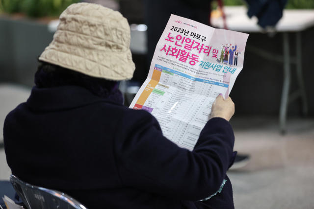 15일 오전 한 시민이 서울 마포구청에서 열린 노인 일자리 박람회에서 안내문을 읽고 있다. 연합뉴스
