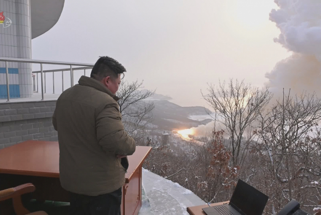 김정은 북한 국방위원장이 지난 15일 동창리 서해위성발사장에서 고체 연료 로켓엔진의 지상 시험을 멀리서 지켜보고 있다. 조선중앙통신·연합뉴스