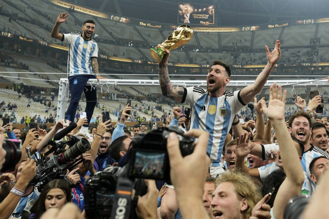 아르헨티나의 리오넬 메시(가운데)가 19일 카타르 루사일 스타디움에서 열린 프랑스와의 2022 카타르 월드컵 결승전에서 승리한 후 우승컵을 들고 동료, 팬들과 기뻐하고 있다. AP연합뉴스
