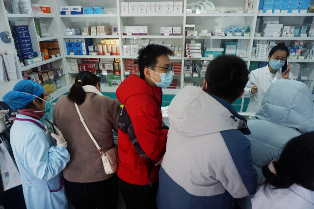 중국에서 코로나19 감염자가 폭등하는 가운데 19일 저장성 항저우의 한 약국에서 시민들이 코로나19 신속항원검사 키트를 구매하기 위해 줄 서 있다. AFP연합뉴스