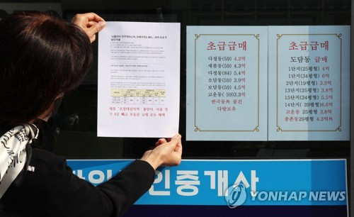 10일 세종시의 한 공인중개사무소 관계자가 사무실 유리창에 안내문을 부착하고 있다. 연합뉴스