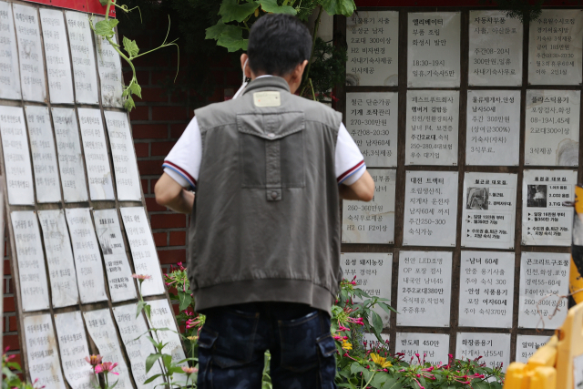 한 시민이 벽에 붙은 구인광고를 보고 있다. 연합뉴스