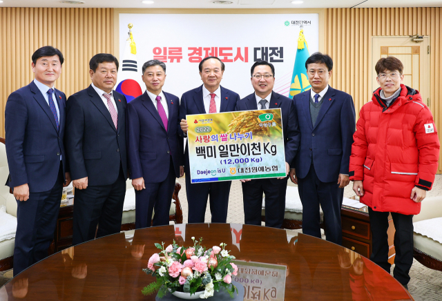 대전원예농협 김의영(왼쪽에서 네번째) 조합장이 이장우(″다섯번째) 대전시장에게 사랑의 쌀 1만2000kg을 기탁하고 있다. 사진제공=대전시