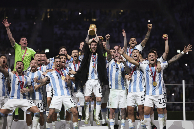 19일 2022 카타르 월드컵 결승전에서 프랑스를 승부차기 끝에 꺾고 우승한 아르헨티나의 리오넬 메시와 동료 선수들이 트로피를 들고 기뻐하고 있다. 신화연합뉴스