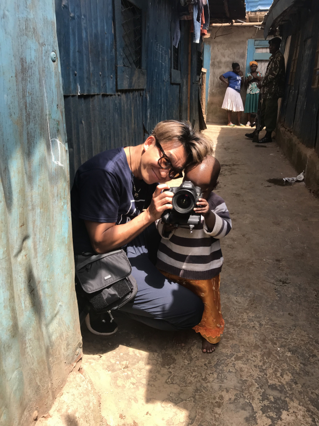 2018년 컴패션과 함께 케냐로 떠난 봉사 여행에서 김명중 사진작가가 현지 어린이와 함께 사진을 찍고 있다. 사진 제공=한국컴패션