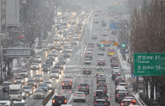 눈이 내린 지난 6일 오전 경기도 수원시 1번 국도에서 차량이 서행하고 있다. 연합뉴스