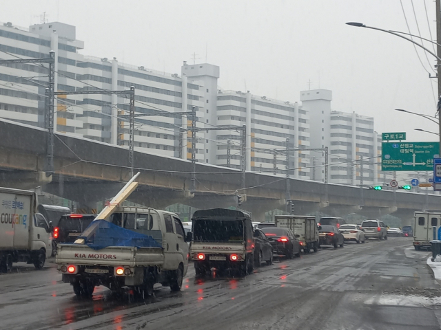 대설특보가 발효된 21일 오전 서울 영등포구의 한 도로에 차들이 길게 늘어서 있다. 이건율 기자