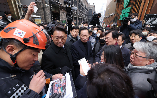 우상호 이태원 참사 국정조사특별위원회 위원장과 특조위원들이 21일 서울 용산구 이태원 참사 현장을 찾아 최성범 용산소방서장의 브리핑을 들으며 대화하고 있다./연합뉴스