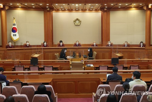 유남석(가운데) 헌법재판소장을 비롯한 재판관들이 22일 오후 서울 종로구 헌법재판소 대심판정에 입장해 자리에 앉아 있다. 연합뉴스