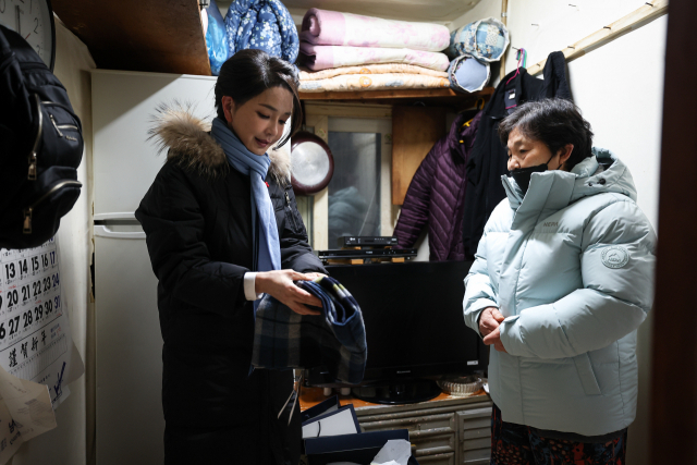 김건희 여사가 22일 서울 남대문 쪽방촌에서 열린 ‘이웃과 함께하는 2022 찾아가는 성탄절, 희망박스 나눔행사’에서 쪽방촌 어르신을 찾아가 식료품 등이 담긴 ‘희망박스’와 함께 겨울점퍼와 머플러를 전달하고 있다. 사진=대통령실