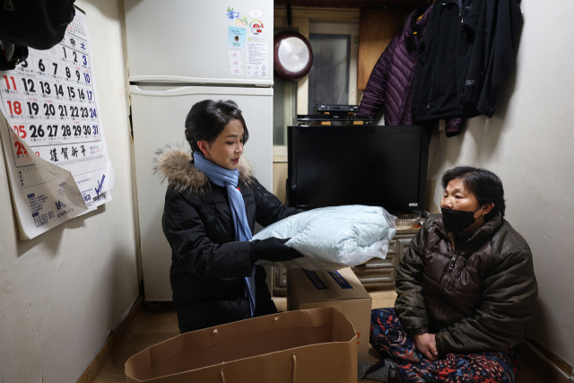 김건희 여사가 22일 서울 남대문 쪽방촌에서 열린 ‘이웃과 함께하는 2022 찾아가는 성탄절, 희망박스 나눔행사’에서 쪽방촌 어르신을 찾아가 식료품 등이 담긴 ‘희망박스’와 함께 겨울점퍼와 머플러를 전달하고 있다. 사진=대통령실