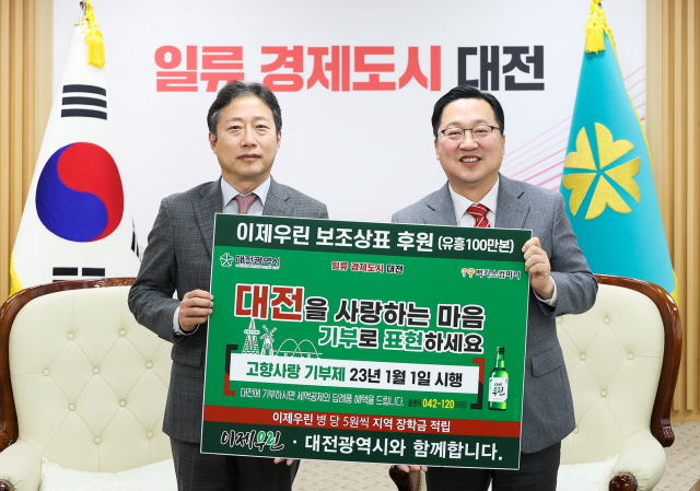 김규식(왼쪽) 맥키스컴퍼니 대표이사가 이장우(오른쪽) 대전시장에게 고향사랑기부제 홍보를 위한 보조상표를 전달하고 있다. 사진제공=대전시