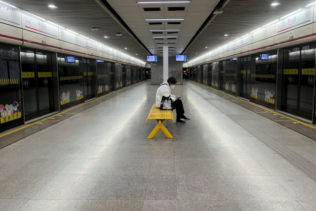 중국 상하이의 텅 빈 지하철역에서 한 승객이 20일 마스크를 낀 채 열차를 기다리고 있다. 로이터연합뉴스
