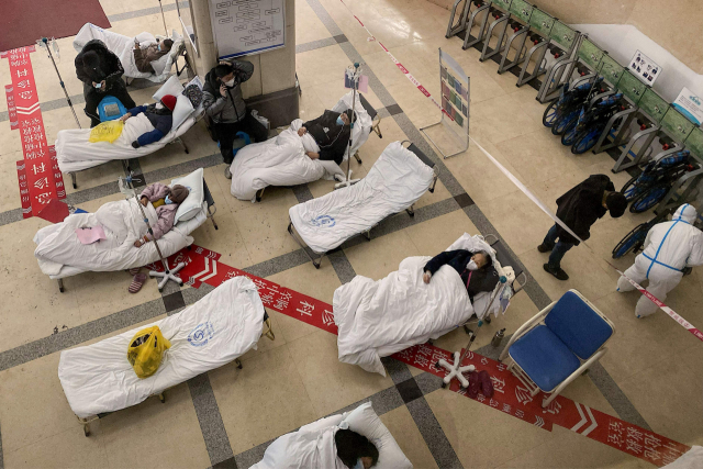 23일 중국 남서부 충칭의 한 인민병원 로비에 임시로 마련된 병상에 코로나19 환자들이 누워 있다. AFP연합뉴스
