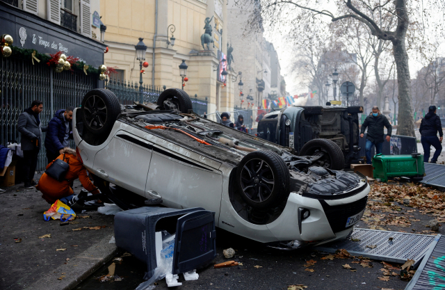 24일(현지 시간) 프랑스 파리에서 쿠르드족을 겨냥한 총격 살해 사건을 규탄하는 시위로 차량이 뒤집혀 있다. 로이터연합뉴스