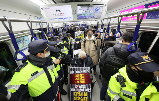 전국장애인차별철폐연대 회원들이 19일 서울 지하철 1호선 용산역에서 기습시위를 하고 있다. 연합뉴스