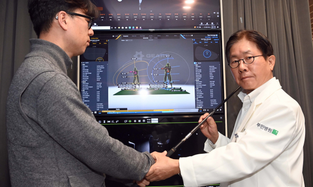 서경묵(오른쪽) 서울부민병원 스포츠재활센터장이 3D골프스윙 분석 장비를 이용해 골퍼의 스윙 습관과 부상 위험을 확인하고 있다. 이호재 기자
