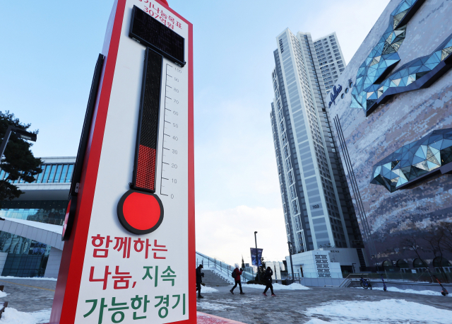 시민들이 경기도 수원시 영통구 수원컨벤션센터 앞에 설치된 ‘사랑의 온도탑’을 지나고 있다. 수원=연합뉴스