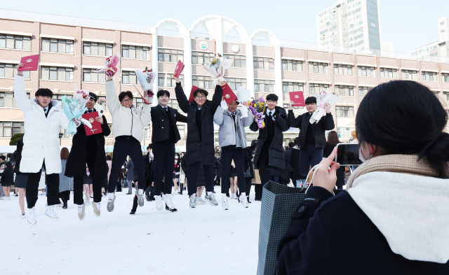 경기 군포시 수리고등학교 학생들이 19일 졸업식을 마친 뒤 하늘을 향해 뛰고 있다. 군포=연합뉴스