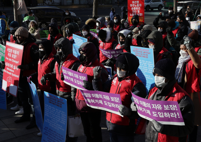 18일 오후 서울 광화문 파이낸스 빌딩 앞에서 열린 세계 이주 노동자의 날 기념 집회에서 참가자들이 구호를 외치고 있다. 연합뉴스