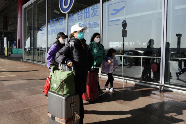 13일 베이징 공항에서 관광객들이 캐리어를 끌고 이동하고 있다. AP연합뉴스