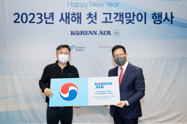 송보영(오른쪽) 대한항공 여객사업본부장이 새해 첫 손님으로 선정된 유병호 씨에게 선물을 전달하고 있다. 사진 제공=대한항공