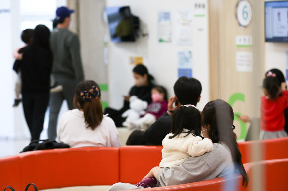 서울의 한 소아과에서 독감 주사를 맞으려는 시민들이 아이들과 함께 순서를 기다리고 있다. 연합뉴스