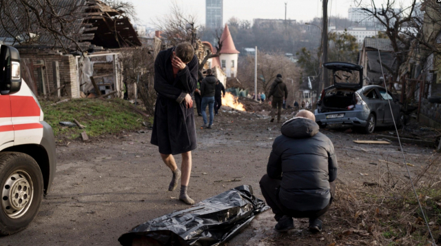 31일 우크라이나 수도 키이우가 미사일 공습을 받아 최소 21명의 사상자가 나온 가운데, 한 남성이 숨진 아내의 시신 옆에서 눈물을 훔치고 있다. AP연합뉴스