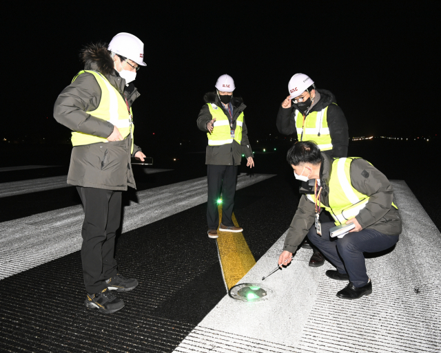 윤형중 한국공항공사 사장(왼쪽 두 번째)이 지난 1일 김포공항 새해 첫 항공기 운항 특별 안전 점검에서 항공기 이착륙의 길잡이가 되는 활주로 시단에서 유도로 중심선 등을 점검하고 있다./연합뉴스