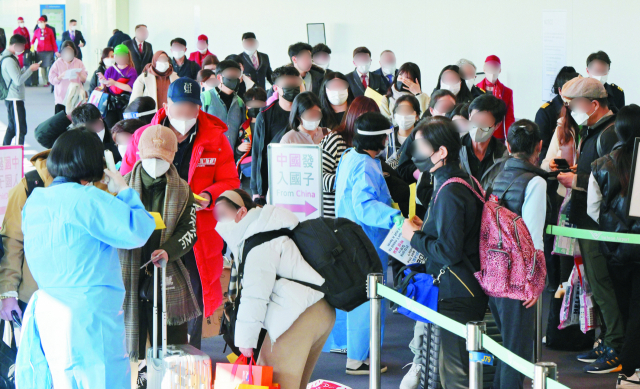 2일 인천국제공항 제1여객터미널 입국장에서 공항 관계자들이 중국발 입국자를 분류하고 있다. 방역 당국은 이날부터 중국에서 항공편이나 배편으로 입국하는 모든 사람에 대해 코로나19 유전자증폭(PCR) 검사를 실시한다. 영종도=권욱 기자