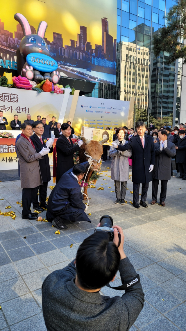 2일 서울 여의도 한국거래소 본관 앞마당에서 진행된 ‘2023 증시대동제’에서 주요 참석자들이 증시 활황을 염원하는 황소 앞에서 박수를 치고 있다./서울경제DB