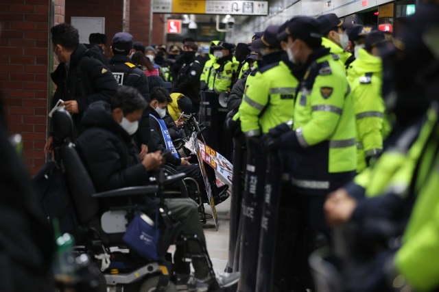 전국장애인차별철폐연대(전장연) 회원들이 2일 오전 서울 지하철 4호선 삼각지역 승강장에서 지하철 탑승을 시도하는 가운데 경찰이 배치돼 있다. 연합뉴스