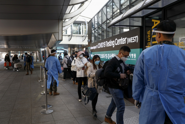 중국발 입국자에 대해 코로나19 검사를 하는 고강도 방역 대책이 시행된 2일 인천국제공항 제1터미널 입국장에서 중국발 입국자들이 방역 관계자들의 안내를 받고 있다. 영종도=권욱 기자