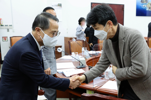 김규현(왼쪽) 국정원장이 5일 국회에서 열린 정보위 전체회의에서 윤건영 더불어민주당 의원과 악수하고 있다. 연합뉴스