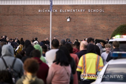 6일(현지시간) 총격 사고가 발생한 미국 버지니아 뉴포트뉴스의 초등학교 앞에 학부모들이 모여 있다. 이날 6살짜리 1학년생이 30대 여교사를 권총으로 쏴 중태에 빠트렸다. 연합뉴스
