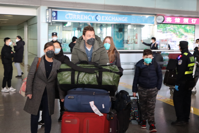 중국이 해외 입국자 격리를 폐지한 첫날인 8일 베이징서우두국제공항에 영국에서 연말 휴가를 보낸 스티븐(가운데) 씨가 가족들과 입국 게이트를 빠져나오고 있다. 김광수 특파원